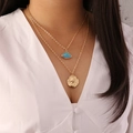 Zweilagige Goldkette mit blauem Fächeranhänger und geprägter Münze am Modell getragen - Blau