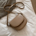 Khaki PU leather mini saddle bag with gold hardware shown on a soft white fabric background - Khaki