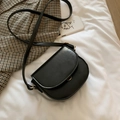 Mini black PU leather saddle crossbody bag with gold hardware on white background - Black