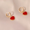 Elegante gouden hartoorbellen met rood emaille op een lichte glanzende satijnen achtergrond - Rood