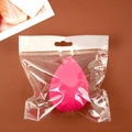 Single pink beauty blender sponge in transparent zip-lock bag packaging on a desk - Waterdrop Shape (Individual Bag) / Rose Red