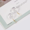 Dettaglio di orecchini a sfera iridescente con ganci dorati su un libro d'epoca - 1398-3 Gancio Dorato Stile Corto / Oro