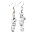 Close-up of dangling stone earrings with white marble texture and silver hooks - White