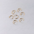 Close-up of seven 10mm gold-plated stainless steel open jump rings for DIY jewelry making - 100 Pcs/Pack / Gold