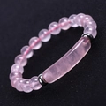 Macro shot of pink crystal bracelet with round beads and a smooth curved center stone - Natural Rose Quartz (SL245A4701)
