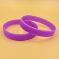 Pair of flexible purple silicone wristbands with smooth finish on yellow background - Purple