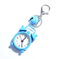 Macro shot of a mini blue alarm clock keychain with a small bell and metal hook - Blue
