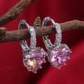Makroaufnahme der rosa herzförmigen Kristallohrringe mit silberner Mikro-Pave-Fassung - Rosa