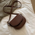 Mini dark brown crescent crossbody bag with flap and gold hardware on a white linen background - Dark Brown