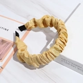 Pleated yellow satin headband with a golden sheen on a white marble background - Yellow