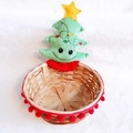 Detail of bamboo Christmas basket with red pom-poms and a plush green tree topper - Christmas Tree Basket