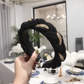 Wide braided black headband featuring pleated fabric and integrated golden chain detail - Black