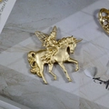 Detalle de broche de unicornio y hada en oro mate vintage sobre fondo de mármol - Estilo A-Hada Cabalgando Unicornio