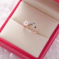 Detailed close-up of a rose gold flower ring with colorful crystals in a jewelry box - 10#14120B (Rose Gold Multi-Gem Dynamic)