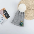 Détail d'un bonnet gris tricoté avec pompon en fausse fourrure et écusson sapin de Noël - Parent-Enfant (50-58CM) / Gris Clair (Sapin de Noël)