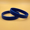 Set of two flexible blue silicone wristbands displayed on a solid yellow background - Blue