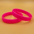 Two bright pink silicone wristbands with smooth finish shown in studio lighting - Rose Red
