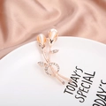 Rose gold flower brooch with opal-like stone and crystals on a white ceramic plate - Rose Gold Calla Lily