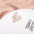 Elegant rose gold musical note brooch with sparkling white crystals on silk backdrop - Musical Note Clef