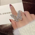 Macro detail of silver butterfly ring with shimmering cubic zirconia inlay on finger - Exaggerated Full Diamond Butterfly Style - Silver