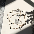 Elegant gold chain necklace with white square cat-eye stone beads on paper background - Gold + Milky White