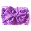Detail van een paarse babyhoofdband met grote strik en zachte geplooide textuurstof - Donkerpaars