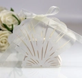 Close-up of laser-cut white shell wedding favor box with an elegant ribbon bow detail - Ivory