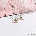 White NOEL Christmas alloy charm with gold trim and holly leaf detail, size 19x15mm - No.36 NOEL Letters