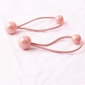 Détail d'élastiques à cheveux roses pour filles avec des perles rondes sur tissu doux - Rose