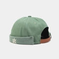 Detail of green dockers cap featuring white rudder embroidery and leather strap - Grass Green With Helm Embroidery