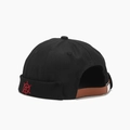 Close-up of black docker hat with red anchor embroidery and brown leather strap - Black With Helm Embroidery