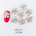 Macro view of 13x13mm gold metal flower nail charm with AB rhinestones on a red nail - 5114 Iridescent White