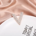 Elegant V-shaped brooch in rose gold with shimmering pavé crystal setting on a silk background - Rose Gold V Shape