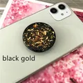 Detail of round black and gold foil phone socket stand on white smartphone surface - Expanding Stand / Black Base Gold Foil