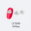 Macro view of 8x8mm 3D silver snowflake nail charms with zircon on a red nail - 5096 White