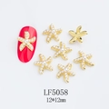 Macro detail of 12mm gold starfish nail charms with white pearls on red nail sample - Gold Pearl Starfish Style (5058)