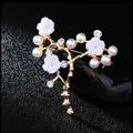 Elegant gold flower branch brooch with white petals, pearls and crystals on black background - No. 22-Gold Shell Flower Branch