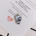 Macro detail of irregular baroque grey pearl pendant with elegant gold plated edge - Gray