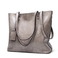 Detail view of silver gray tote bag with synthetic leather texture and metal rivets - Gray