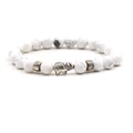Detailed close-up of white turquoise bead bracelet featuring a silver elephant charm - Howlite