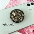Macro detail of round light gold foil glitter flake phone expansion stand on green smartphone - Expanding Stand / Black Base Light Gold Foil