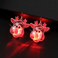 Makroaufnahme leuchtend roter Rentier-Weihnachtsohrringe mit LED-Licht auf dunklem Hintergrund - Transparentes Rentier