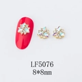 Macro view of 8x8mm flower nail art charm with rhinestones and gold alloy base - 5076 AB Color