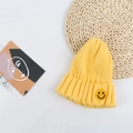 Detail of chunky knit yellow beanie with a smiley face patch and thick woven texture - 50-56cm / Yellow