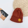 Detail of reddish-brown ribbed knit beanie with a yellow smiley face embroidered patch - 50-56cm / Caramel