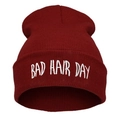 Close-up of burgundy knit beanie featuring white Bad Hair Day embroidery detail - Burgundy