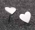 Macro shot of minimalist heart-shaped stainless steel stud earrings on black texture - Heart / Steel