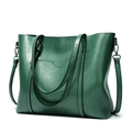 Detail of forest green tote bag featuring grainy leather texture and adjustable strap - Green