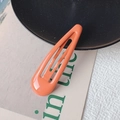 Single bright orange teardrop metal snap hair clip for women in minimalist setting - Orange