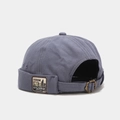 Detail of gray-blue canvas docker hat featuring a metal buckle and vintage leather patch - Adjustable / Standing Bear Haze Blue